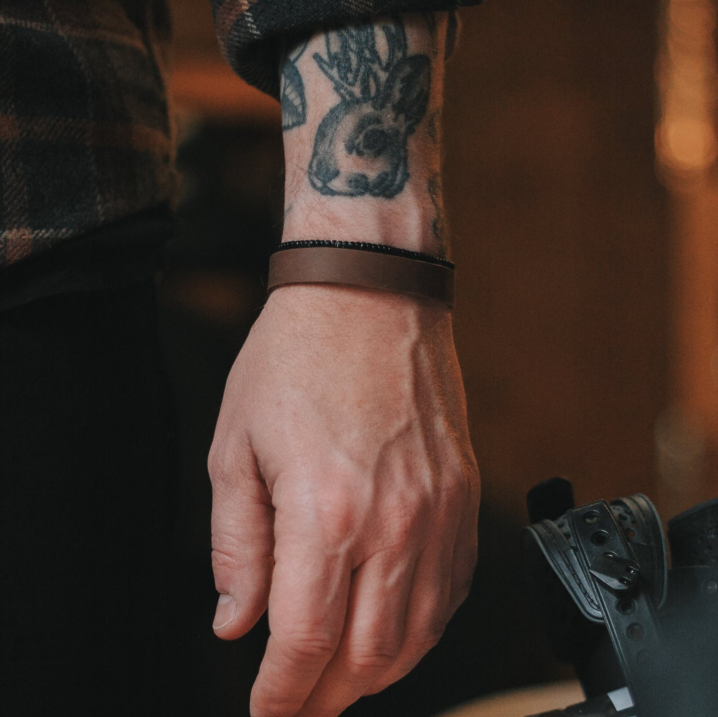 Bracelet de cuir ajustable avec embouts en acier inoxydable et cordes de nylon.