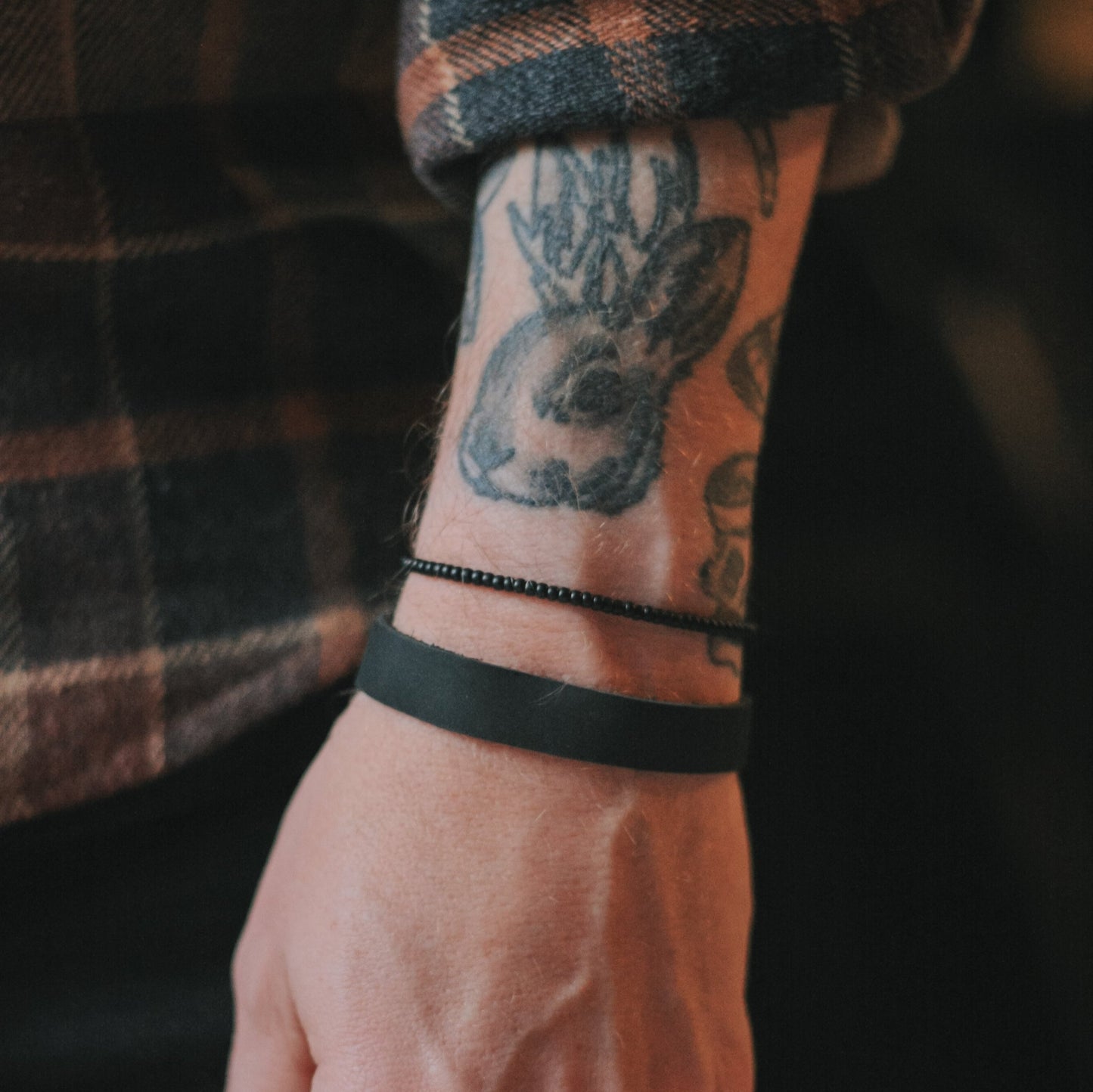 Bracelet de cuir ajustable avec embouts en acier inoxydable et cordes de nylon.