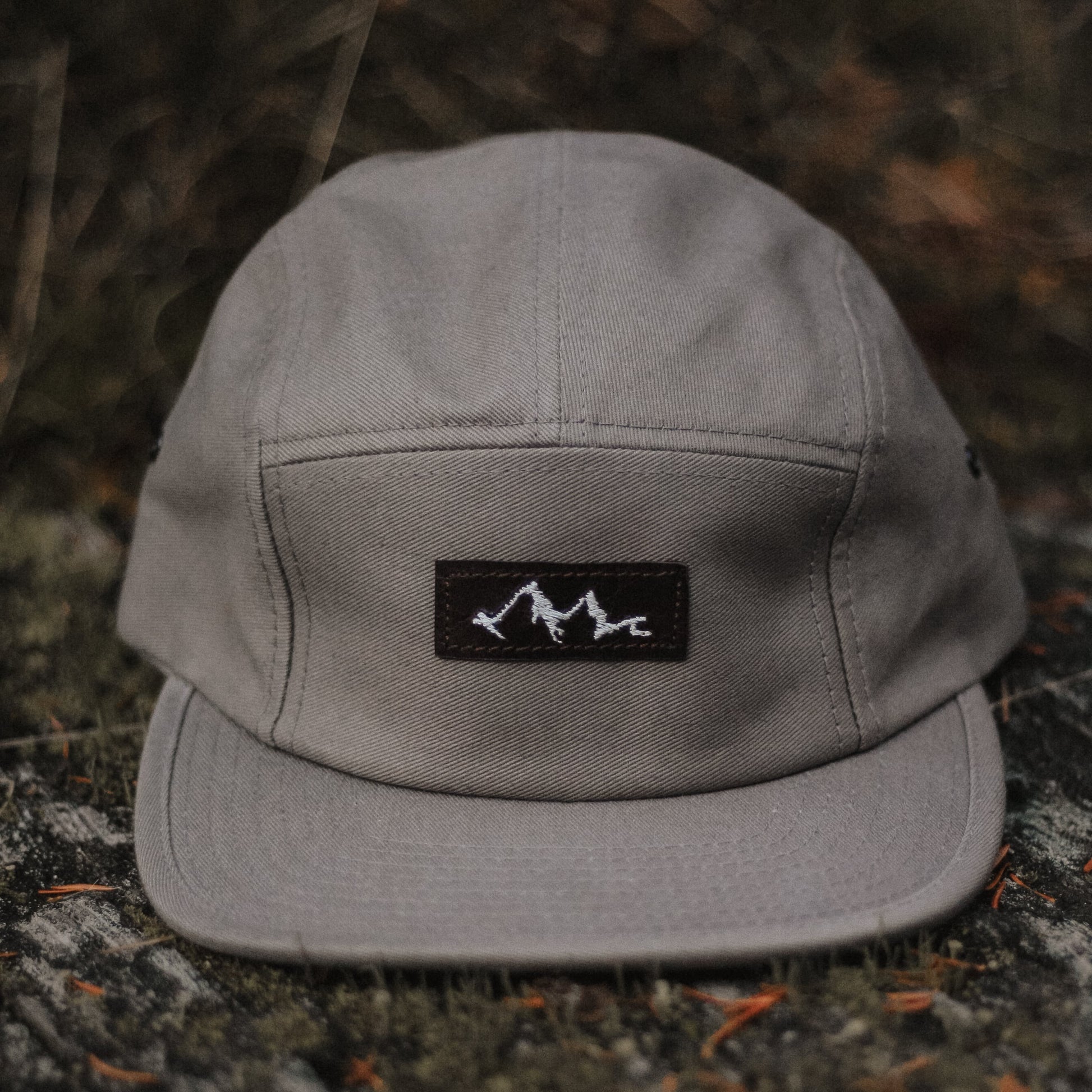 casquette 5 panneaux grise avec logo en cuir brodé montagne et vague