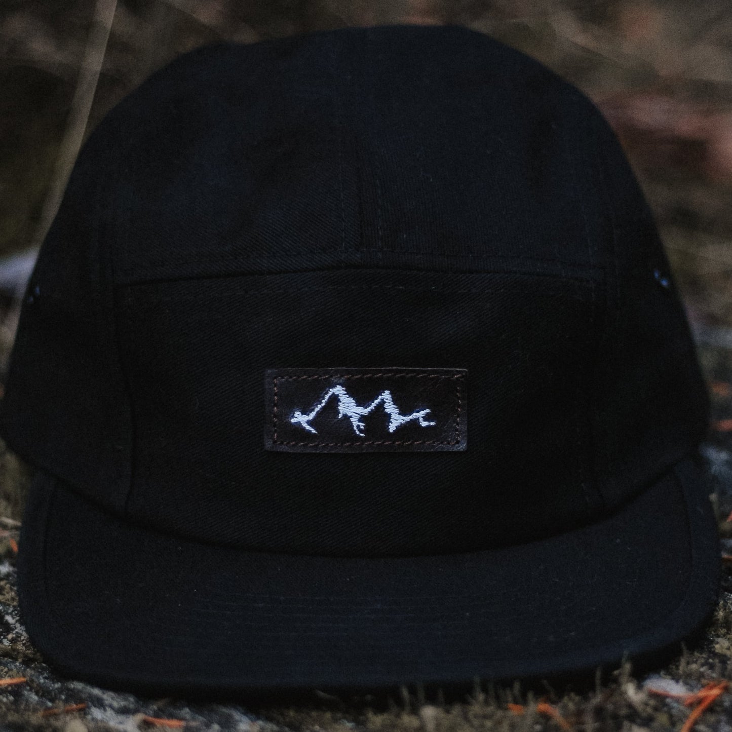 casquette 5 panneaux noire avec logo en cuir brodé montagne et vague